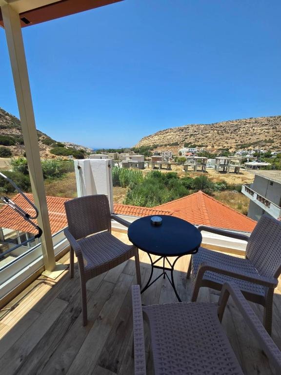 Balcony table and chairs with a view over Matala and the hills