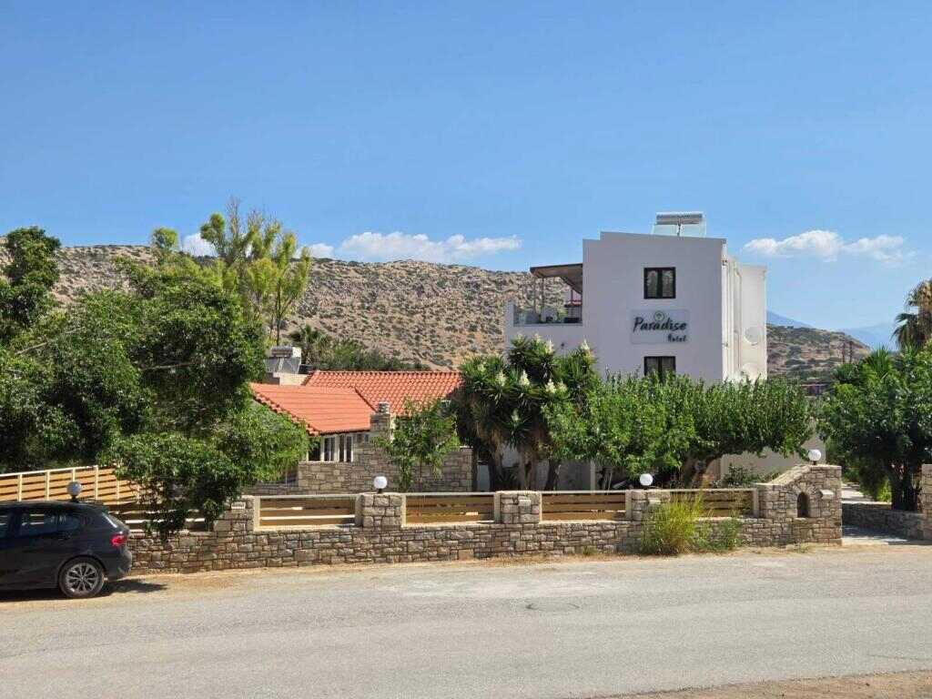 The whitewashed hotel building and garden in Matala, Crete